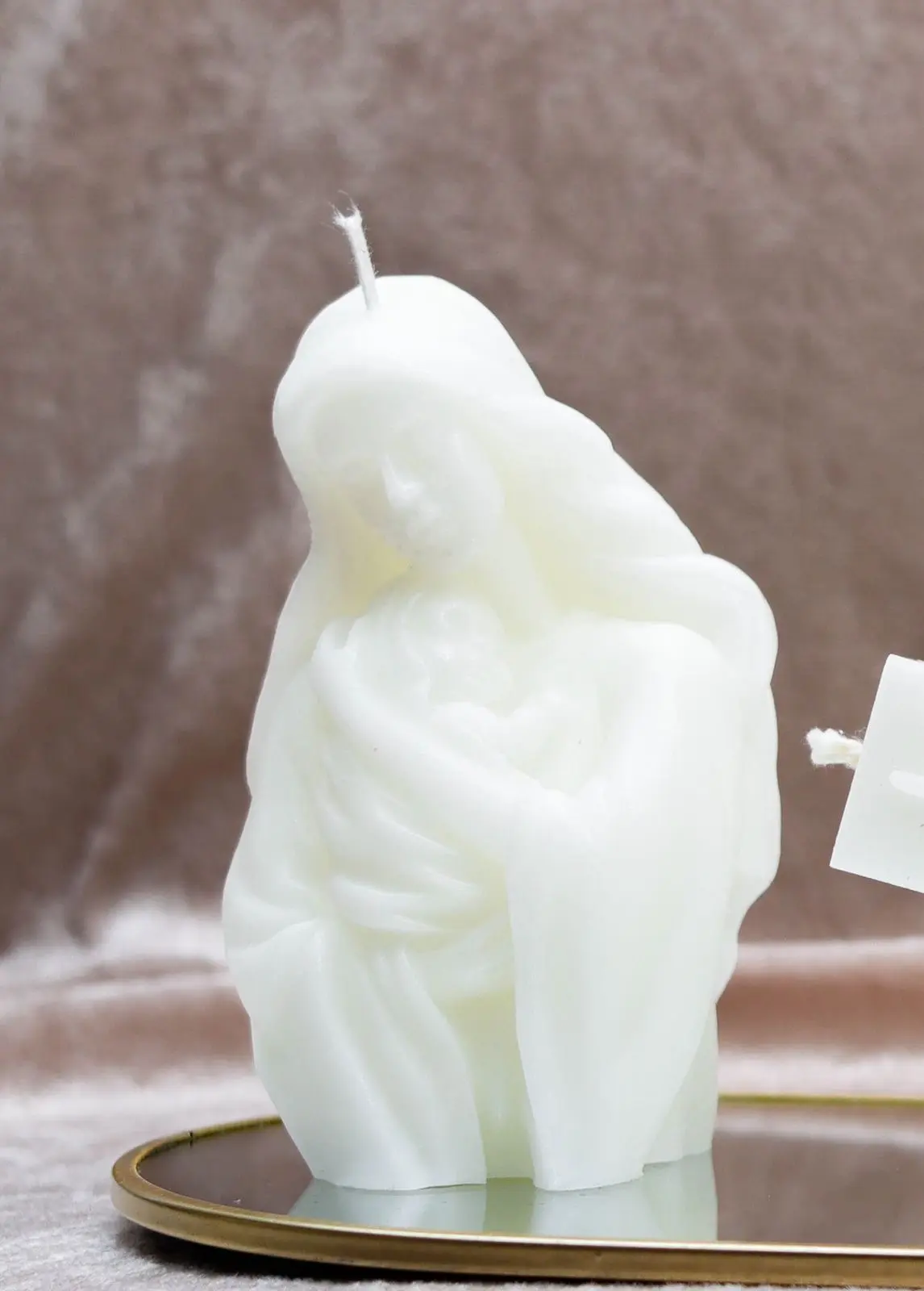 White candle of a mother holding her baby in her arms.